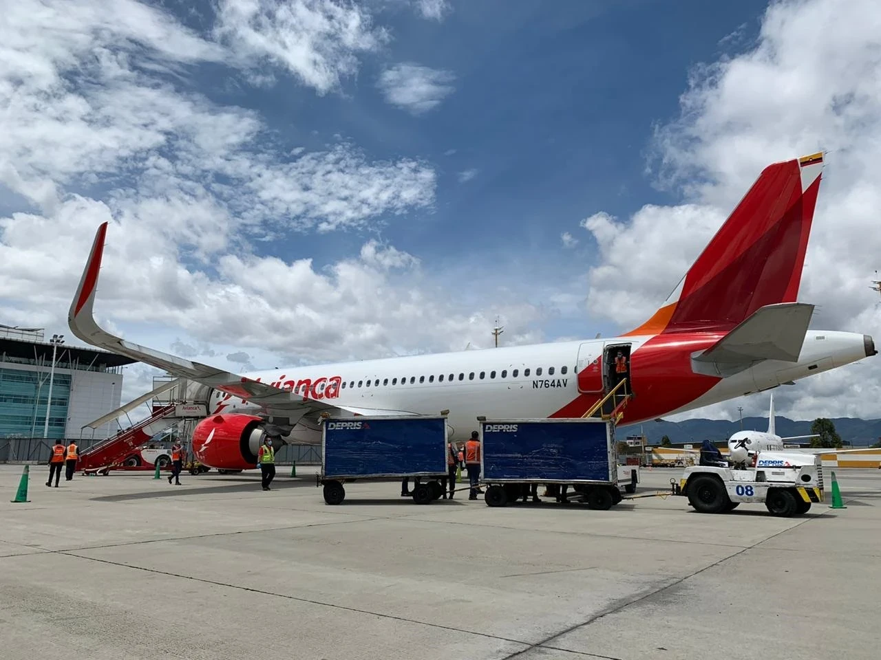 Deprisa cargo carts and ground crew beside an Avianca aircraft at San Andrés airport.